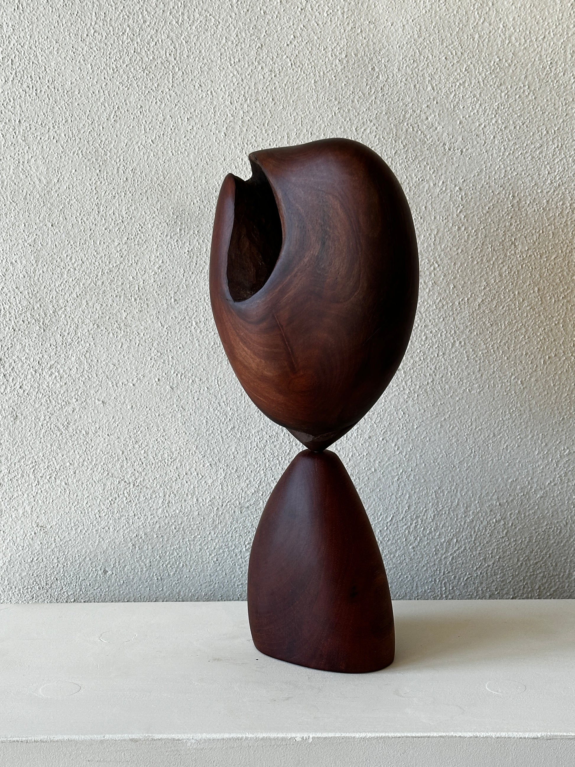 Wooden abstract sculpture on a textured wall